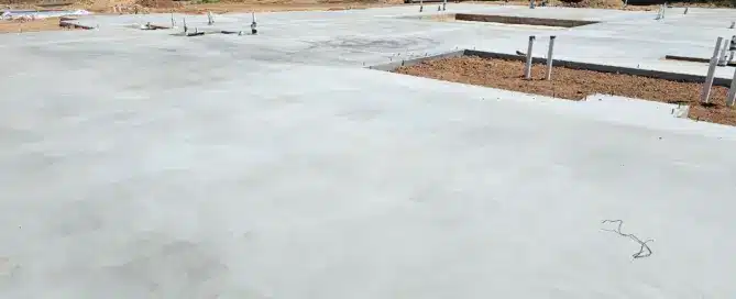 Wide-angle view of a massive 13,800-square-foot custom home foundation under construction in North Albuquerque Acres by M&M Concrete, showcasing precision formwork and structural reinforcement.