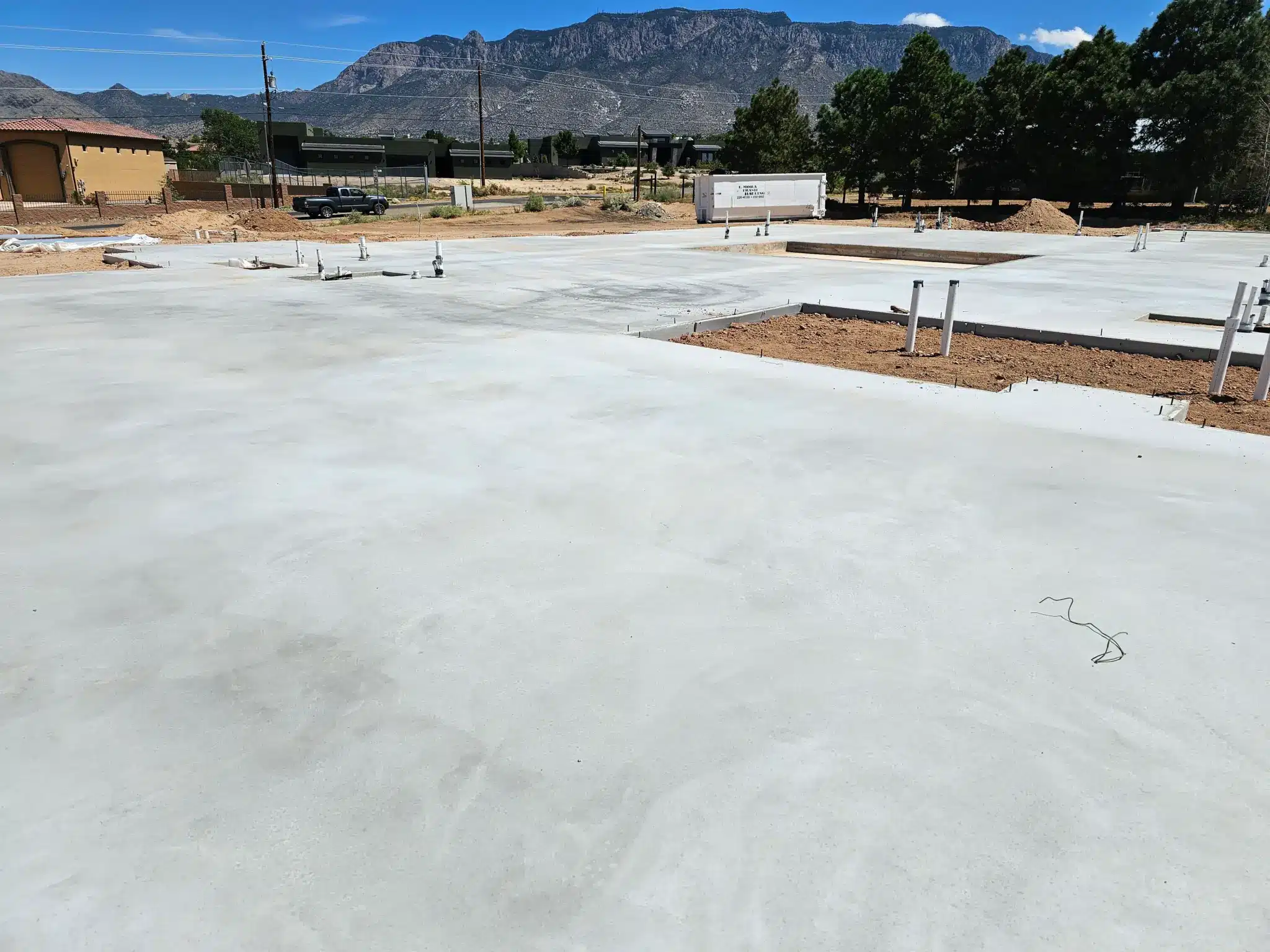 Wide-angle view of a massive 13,800-square-foot custom home foundation under construction in North Albuquerque Acres by M&M Concrete, showcasing precision formwork and structural reinforcement.