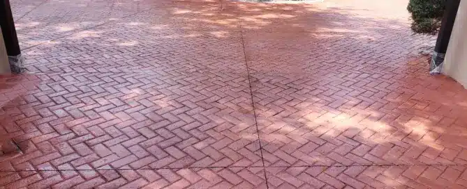 5200 sqft stamped concrete parking lot and driveway in Los Ranchos de Albuquerque featuring a red brick herringbone pattern with gray two-tone joints.